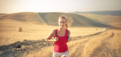 A woman jogging through vast, golden wheat fields under the summer sun, symbolizing freedom and adventure.