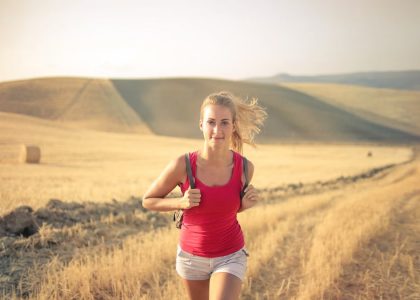 A woman jogging through vast, golden wheat fields under the summer sun, symbolizing freedom and adventure.